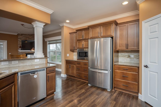 kitchen with ornate columns, stainless steel appliances, dark hardwood / wood-style floors, and ornamental molding