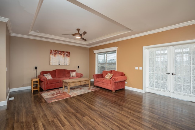 living room featuring a raised ceiling, ceiling fan, and dark hardwood / wood-style flooring