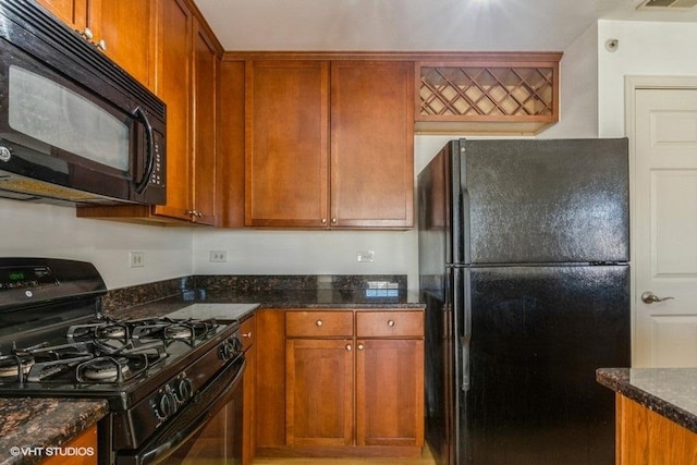 kitchen featuring dark stone counters and black appliances