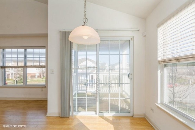 doorway featuring light hardwood / wood-style flooring and vaulted ceiling