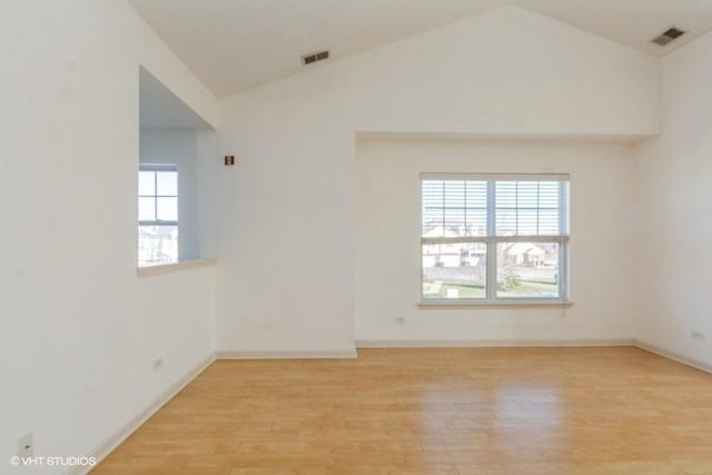 unfurnished room featuring light hardwood / wood-style floors, high vaulted ceiling, and a wealth of natural light