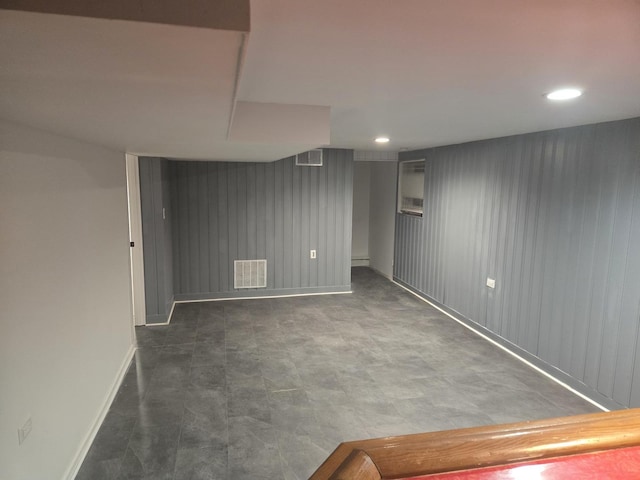 basement featuring wooden walls