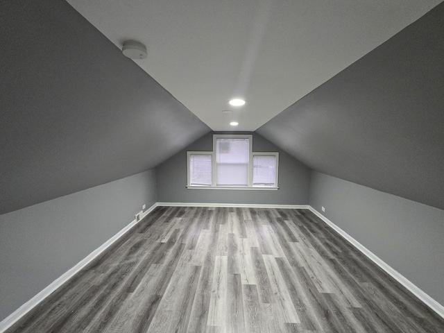 additional living space with lofted ceiling and hardwood / wood-style flooring