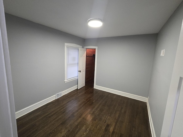 spare room with dark wood-type flooring