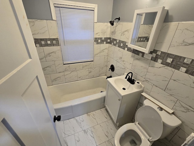 full bathroom with vanity, tiled shower / bath, tile walls, and toilet