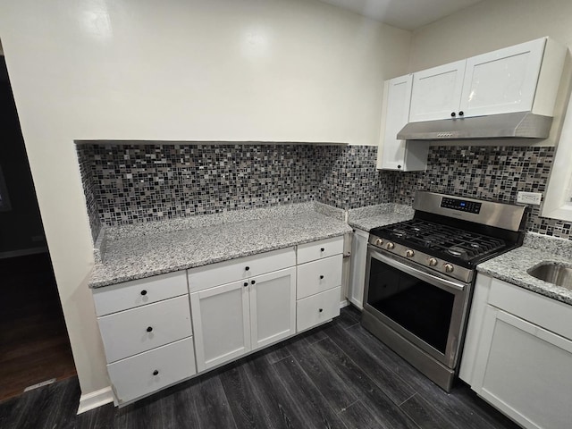 kitchen with decorative backsplash, light stone counters, dark wood-type flooring, white cabinetry, and stainless steel range with gas stovetop