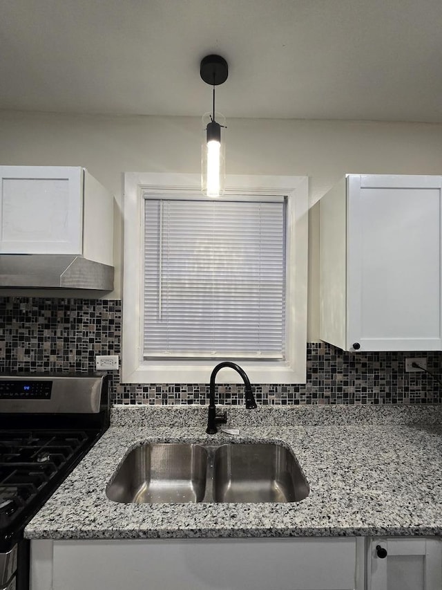 kitchen featuring decorative backsplash, white cabinets, decorative light fixtures, and stainless steel range with gas stovetop