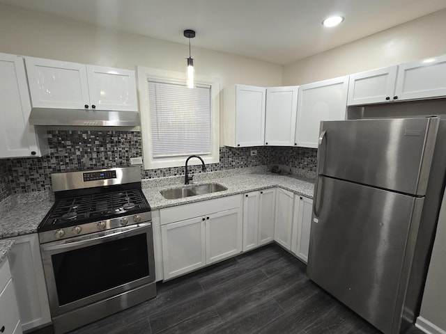 kitchen featuring white cabinetry, sink, stainless steel appliances, and decorative light fixtures