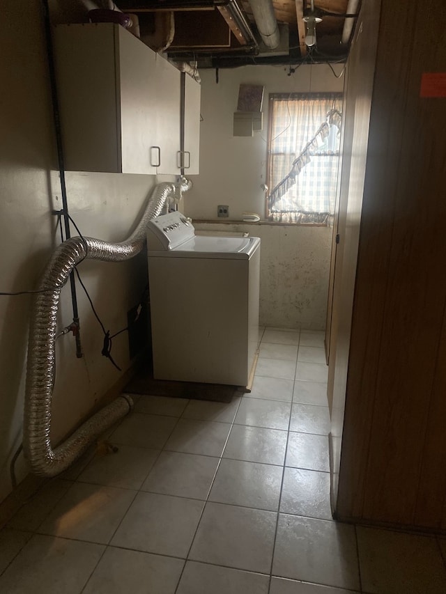 clothes washing area featuring cabinets, light tile patterned flooring, and washer / dryer