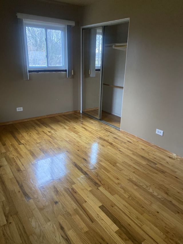 unfurnished bedroom featuring a closet and light hardwood / wood-style floors