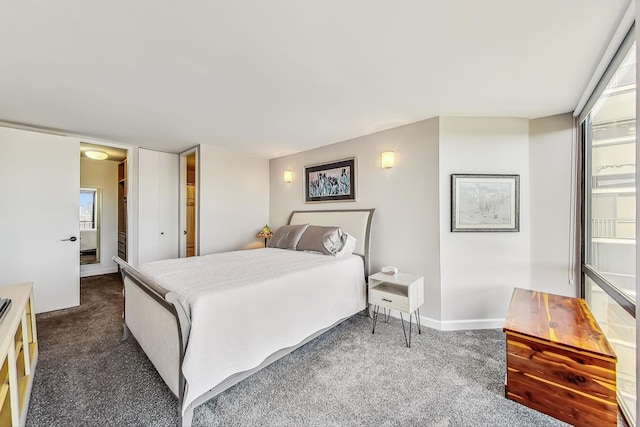 bedroom with dark colored carpet and baseboards