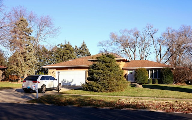 single story home with a garage and a front lawn