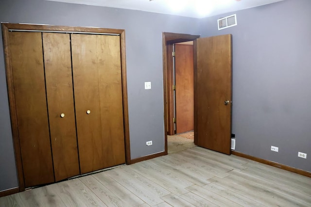 unfurnished bedroom with a closet and light hardwood / wood-style flooring