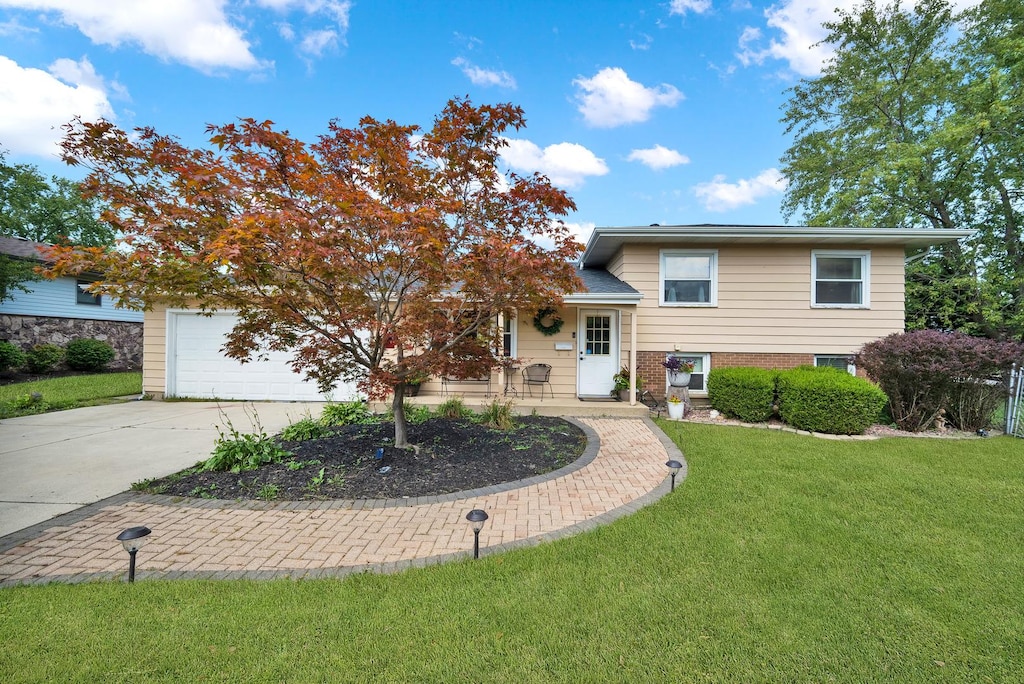 split level home with a garage and a front lawn