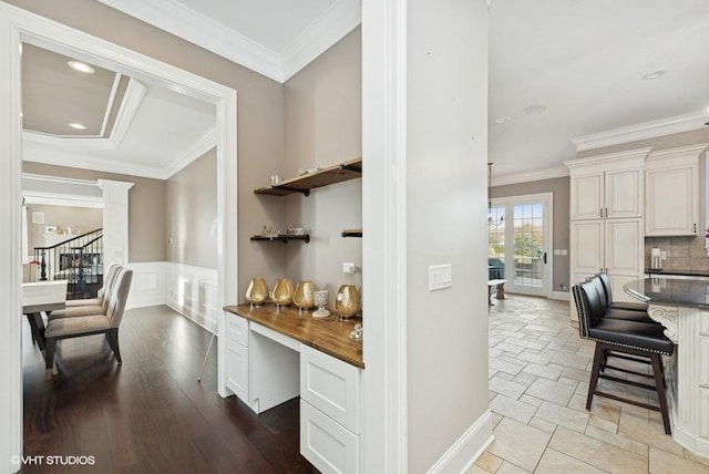 bar featuring wooden counters, white cabinetry, and ornamental molding