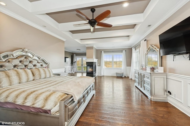 bedroom featuring a tray ceiling, ceiling fan, dark hardwood / wood-style flooring, and ornamental molding