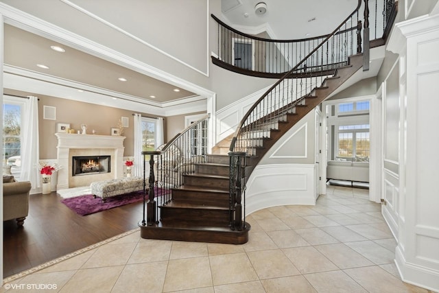 staircase with crown molding, tile patterned flooring, and a healthy amount of sunlight