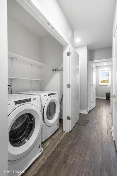 laundry area with washing machine and clothes dryer and dark wood-type flooring