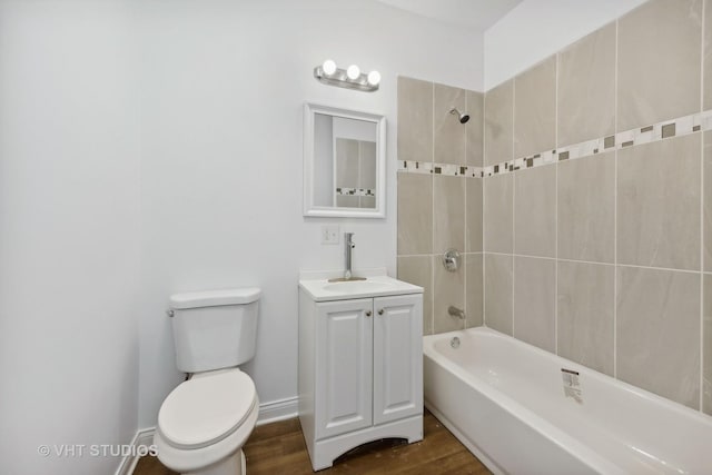 full bathroom featuring vanity, wood-type flooring, tiled shower / bath combo, and toilet