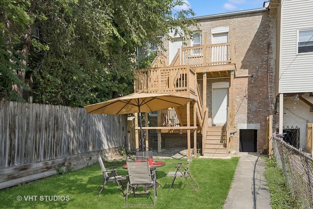 rear view of house featuring a yard and a deck