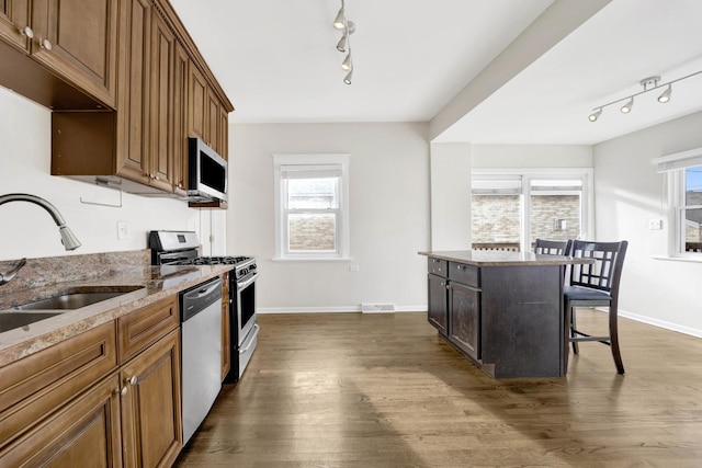 kitchen featuring a healthy amount of sunlight, dark wood-type flooring, and appliances with stainless steel finishes