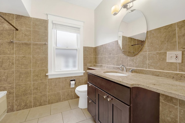 bathroom featuring tile patterned flooring, vanity, tile walls, and toilet