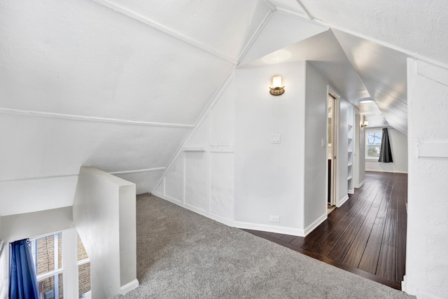 bonus room featuring a textured ceiling, dark hardwood / wood-style flooring, and vaulted ceiling