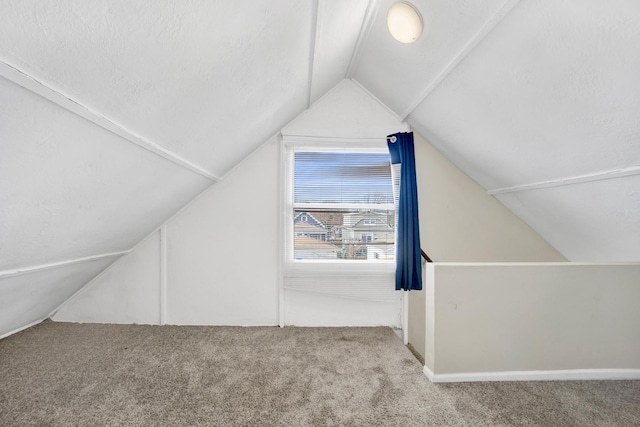 additional living space with light carpet and vaulted ceiling