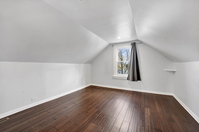 additional living space with hardwood / wood-style floors and vaulted ceiling