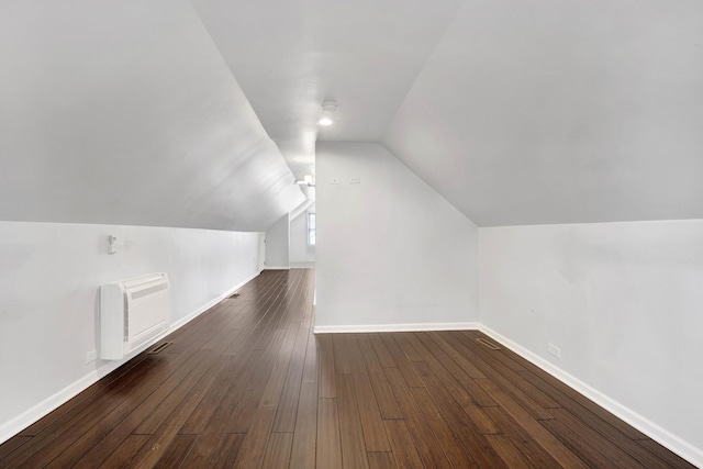 bonus room featuring dark hardwood / wood-style floors, a wall mounted AC, and lofted ceiling