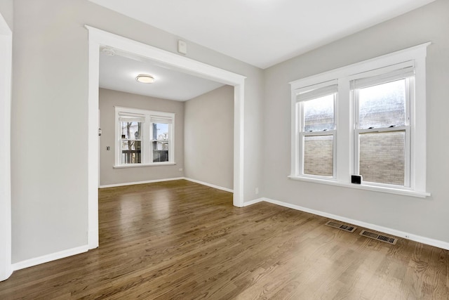 unfurnished room with dark wood-type flooring