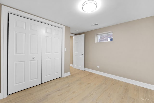 unfurnished bedroom featuring light hardwood / wood-style flooring and a closet