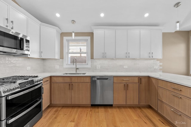 kitchen featuring sink, white cabinets, stainless steel appliances, and light hardwood / wood-style floors