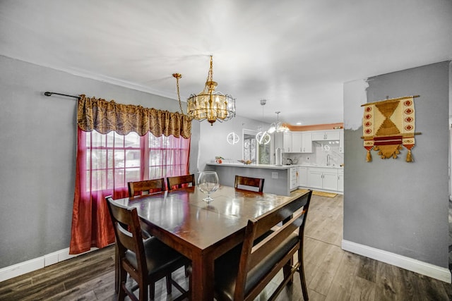 dining room with hardwood / wood-style floors, a notable chandelier, and sink