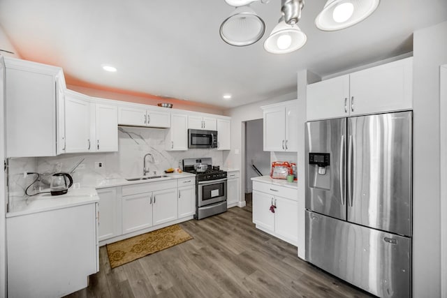 kitchen featuring dark hardwood / wood-style floors, white cabinetry, sink, and appliances with stainless steel finishes