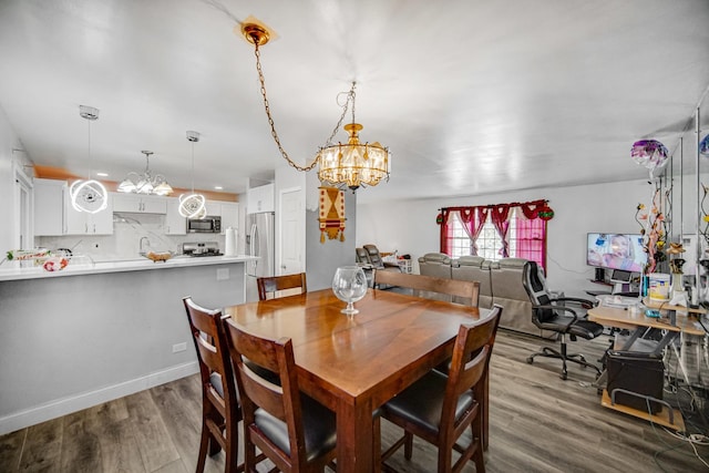 dining area featuring dark wood-type flooring and an inviting chandelier