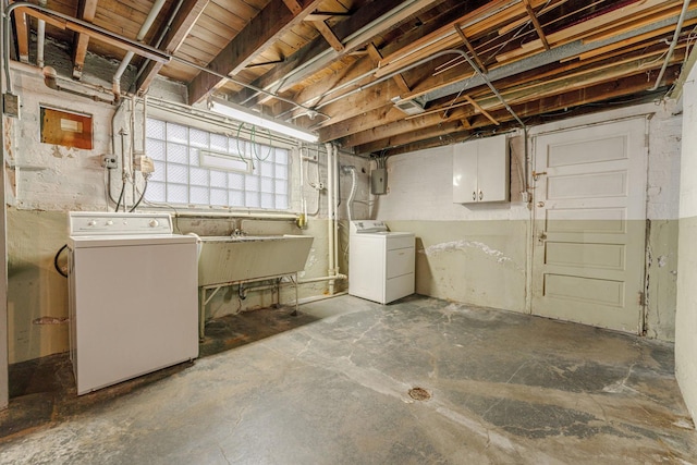 basement featuring sink, electric panel, and independent washer and dryer