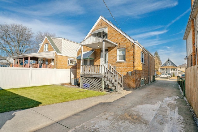 view of front of house featuring a front yard and central air condition unit