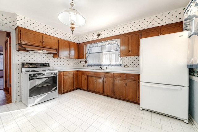 kitchen featuring hanging light fixtures, sink, backsplash, and white appliances