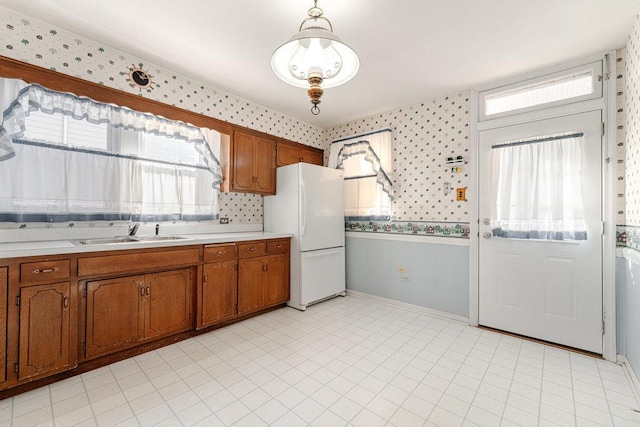 kitchen with white refrigerator, sink, and pendant lighting