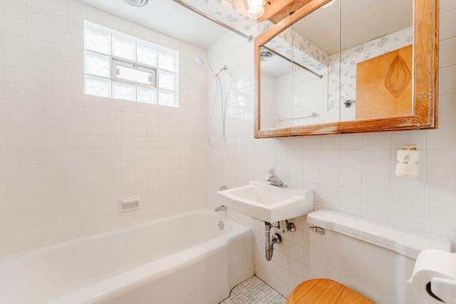 bathroom with tiled shower / bath, toilet, tile walls, and backsplash