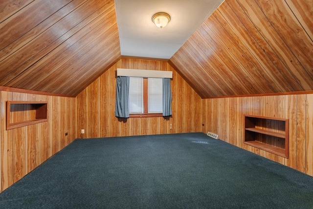 bonus room with built in shelves, vaulted ceiling, wooden ceiling, wooden walls, and carpet