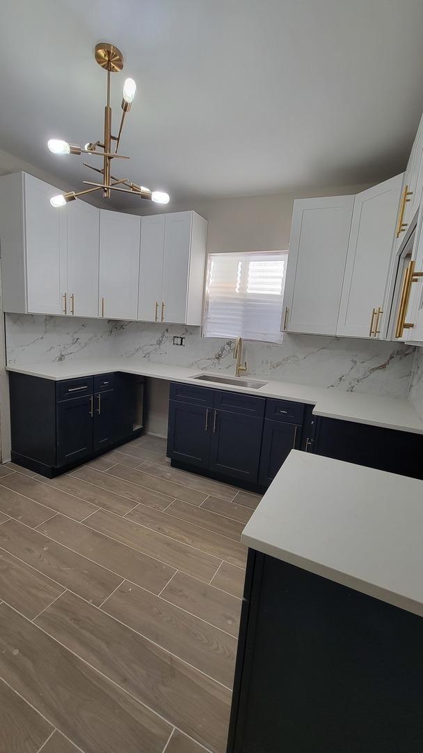 kitchen with white cabinets, decorative backsplash, and sink