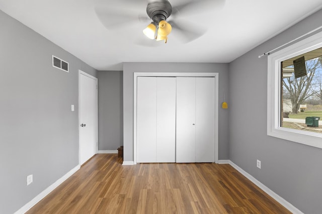 unfurnished bedroom with ceiling fan, a closet, and dark hardwood / wood-style floors