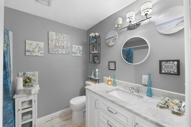 bathroom featuring vanity, hardwood / wood-style flooring, and toilet