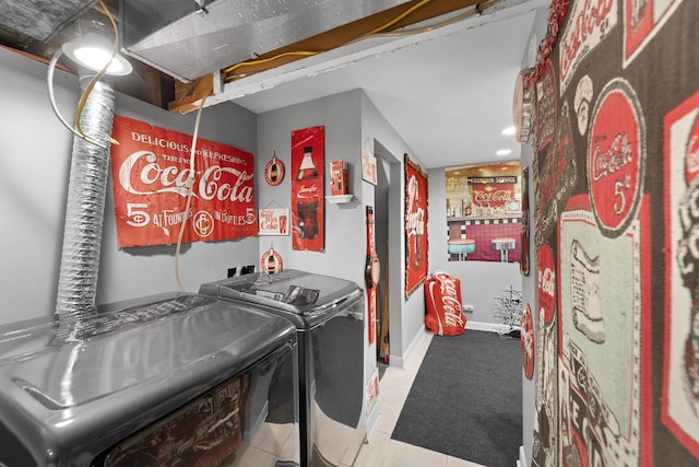 clothes washing area featuring light tile patterned floors and washing machine and clothes dryer