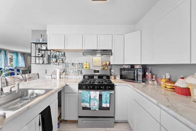 kitchen with white cabinetry, stainless steel gas range oven, and sink