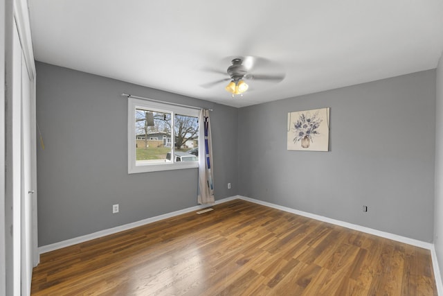 empty room with ceiling fan and dark wood-type flooring