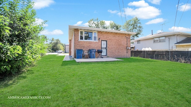 back of property with a yard and a patio