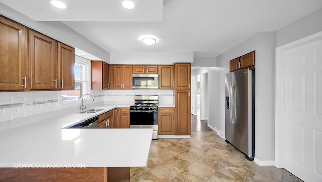 kitchen with kitchen peninsula, decorative backsplash, stainless steel appliances, and sink